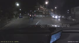 Intoxicated guy jumping and spitting on the vehicles in the middle of the road.