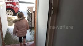 Two girls walk down snowy street