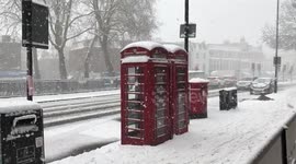 Snow covered phone boxes and pillar box in Islington, London