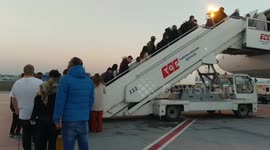 Passengers boarding the exterior steps of Turkish Airlines plane.