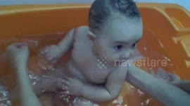 Mother bathing her little baby girl
