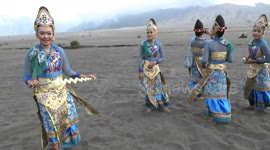 Women in traditional Java dress dance across Mount Bromo's sea of sand