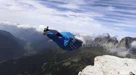 Incredible stunt shows wing-suit pilot dive past Dolomites highliner