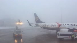 Airport worker defrosting an airplane wing