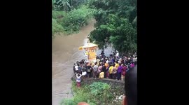 Villagers carry coffin across river in strange funeral ceremony