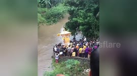 Newsflare Edit - Villagers carry coffin across river in strange funeral ceremony