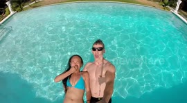 Slow-motion footage of a couple falling backwards into a swimming pool
