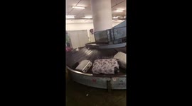 Suitcases filmed hurtling down conveyor belt smashing into metal barrier