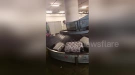 Suitcases filmed hurtling down conveyor belt smashing into metal barrier