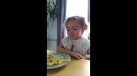 A little girl falls asleep at the table