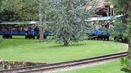 A  little train on rails in an amusement park.