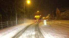 A gritter blasting through the snow