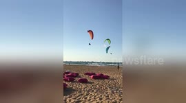 Paraglider crashes into beach after collision with kitesurfer