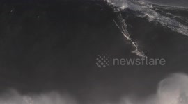 Surfer takes on monster wave off Portugal coast