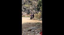 Two children riding motorcycles in mountainous Vietnam