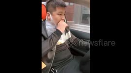 Driver heaves food waste into plastic bag wrapped around his ear