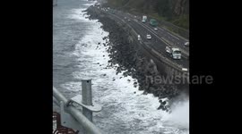 motard pris dans les vagues sur la route du littoral a la réunion,cyclone Eliakim le 16 mars 2018