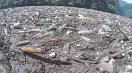 River littered with waste, plastic bottles and rubbish