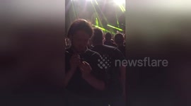Heavy metal fan calmly paints figurine in the middle of concert