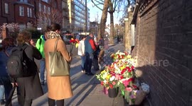 People lay flowers for the victims of Kemerovo fire outside the Russian Embassy in London