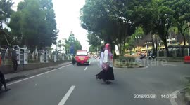 The crosswalker almost got hit by a motorcycle while crossing the street not on the zebra cross