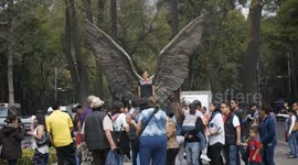 Tourist pose in front of the 'Wings of the City' in Mexico CIty