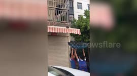Kids use umbrella to rescue kitten on canopy