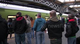 Rival football fans singing together on the train