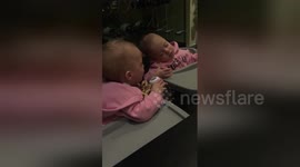 Bored twin desperately tries to wake her napping sister to play