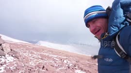 Walker experiences very strong winds on top of mountain in the Brecon Beacons