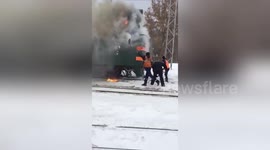 Only in Russia: Railway staff douse train blaze with snow