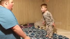 Kid gets blanket ripped out from under him and falls on bed