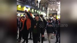 Liverpool fans celebrate victory in Manchester's Piccadilly Station