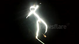 Man in France astonishes crowd wearing an LED light suit while walking a high line