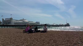 Sunbathers relax on Brighton beach in warm weather