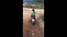 Ten-year-old girl riding a motorbike on a mountain road