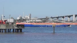 Blue Ship steaming down the Thames under Dartford Bridge