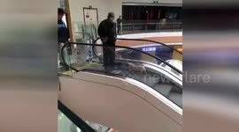 Watch lazy man walk dog by using escalator as a treadmill