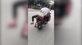 Chinese man ties daughter on motorcycle to send her to school