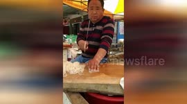 Chinese man nonchalantly slices up jelly noodles at speed with massive cleaver