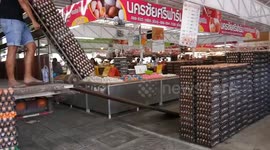 Workers slide down ramp while wheeling hundreds of eggs