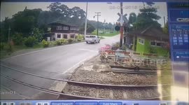 Motorcyclist clotheslined by level crossing seconds before train passes