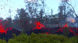 Lava and steam spew from side of cracked road in Hawaii