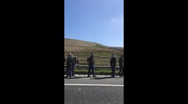 Men strolling down m62 sipping beer