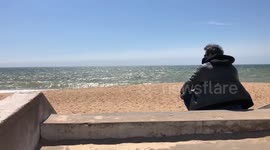 Man on windy sunny beach