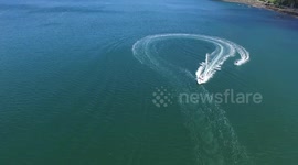 Water skiing by Petone Beach, Gateway to the Hutt Valley. Stunning views of Wellington harbour running alongside the Hutt Motorway. Ski boat action with drone aerials catching water sports on a perfect day in Wellington, New Zealand.