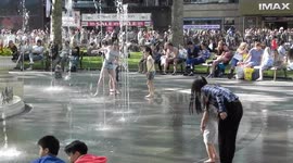 Kids playing in the fountain is the hot sunshine in Leicester Square london by jim connor
