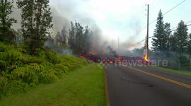 Volcanic lava crosses road in Hawaii and burns electricity pole