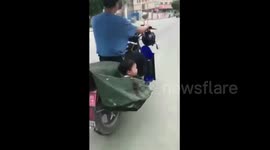 Man carries child in bag hanging on speeding motorcycle