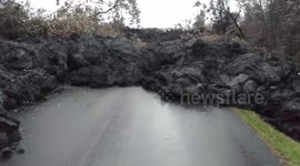 Wall of cooling black lava blocks street in Hawaii